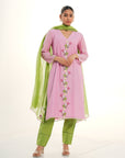 A women wearing light pink colored kurta set with green colored pants with green dupatta.