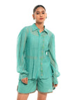 A women wearing full sleeves aqua colored shirt with shorts.