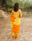 A woman wearing mustard colored Silk Kurta Set with Organza Dupatta.