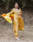 A woman wearing mustard colored Silk Kurta Set with Organza Dupatta.