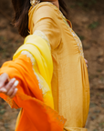 A woman wearing mustard colored Silk Kurta Set with Organza Dupatta.