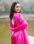 A women wearing pink and green colored Kurta Set with Dupatta.