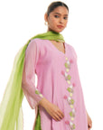 A women wearing light pink colored kurta set with green colored pants with green dupatta.