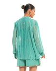 A women wearing full sleeves aqua colored shirt with shorts.
