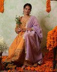 A women wearing Orange Anarkali Kurta Set with Purple Dupatta.