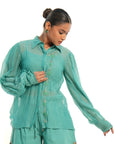 A women wearing full sleeves aqua colored shirt with shorts.
