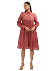 A women wearing maroon colored full sleeves dress with knee length.