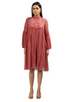 A women wearing maroon colored full sleeves dress with knee length.