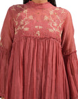 A women wearing maroon colored full sleeves dress with knee length.
