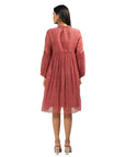 A women wearing maroon colored full sleeves dress with knee length.