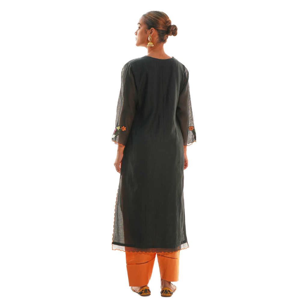 A women wearing black colored kurta set with orange colored pants.