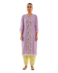 A women wearing purple colored kurta set with lemon colored pants.
