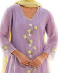 A women wearing purple colored kurta set with lemon colored dupatta.