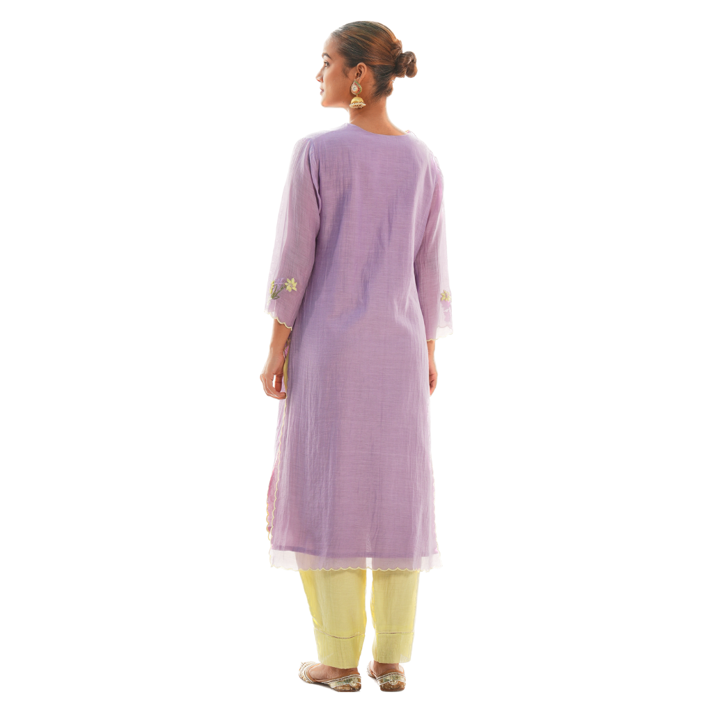 A women wearing purple colored kurta set with lemon colored pants.