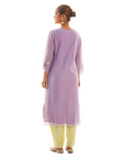A women wearing purple colored kurta set with lemon colored pants.