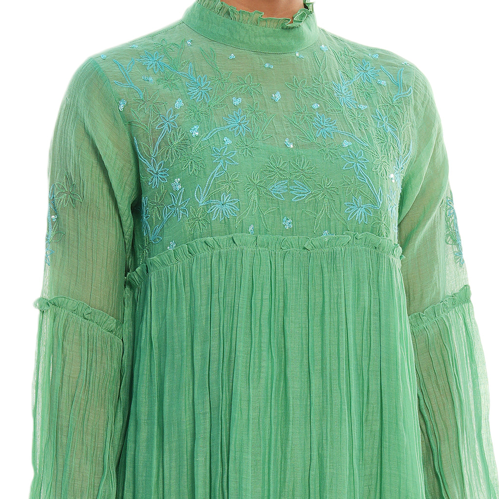 A women wearing green colored full sleeves designer dress.
