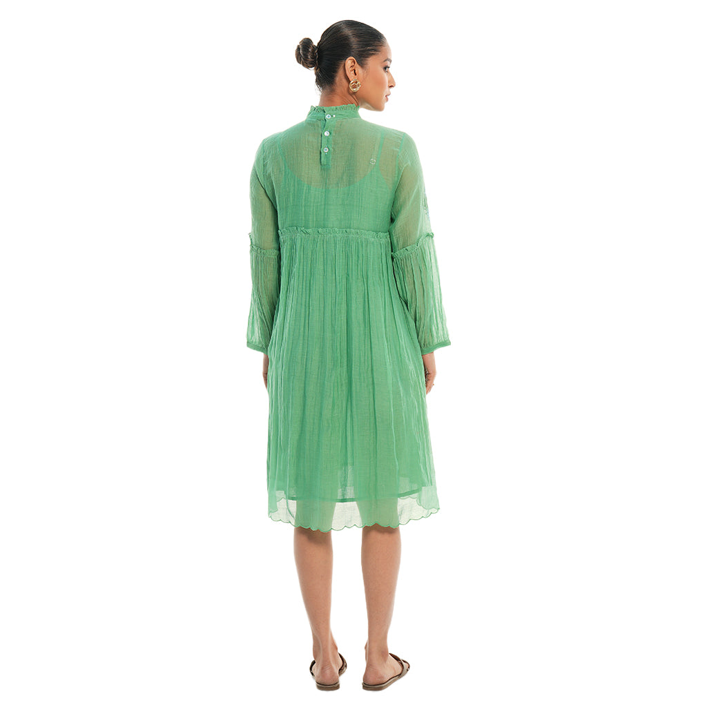 A women wearing green colored full sleeves designer dress with knee length.