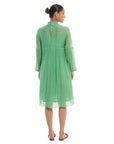 A women wearing green colored full sleeves designer dress with knee length.