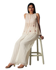 A women wearing pink salt colored designer sleeveless top with palazzo.