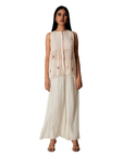A women wearing pink salt colored designer sleeveless top with palazzo.