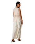 A women wearing pink salt colored designer sleeveless top with palazzo.