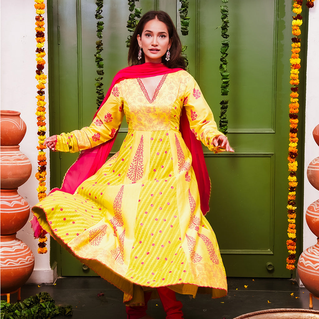A women wearing yellow and pick Chanderi silk Anarkali kurta set with Pink Dupatta.