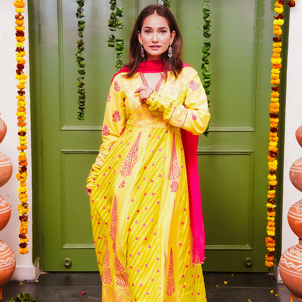 A women wearing yellow and pick Chanderi silk Anarkali kurta set with Pink Dupatta.