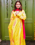 A women wearing yellow and pick Chanderi silk Anarkali kurta set with Pink Dupatta.