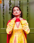 A women wearing yellow and pick Chanderi silk Anarkali kurta set with Pink Dupatta.