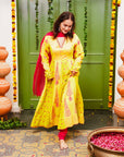 A women wearing yellow and pick Chanderi silk Anarkali kurta set with Pink Dupatta.
