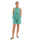 A women wearing aqua colored sleeveless top with aqua colored shorts.