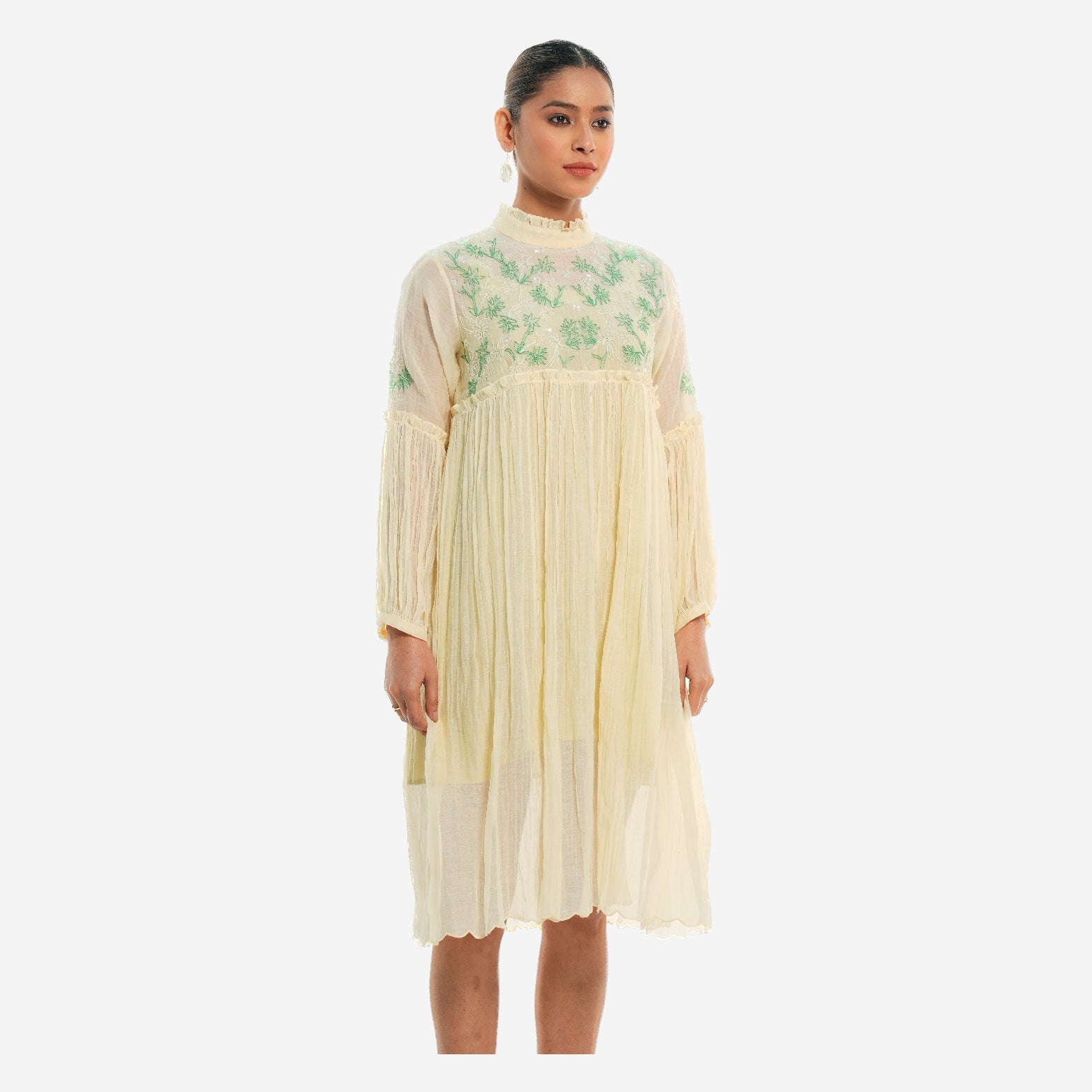 A women wearing white colored full sleeves designer dress with knee length.