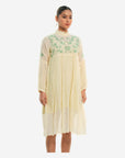 A women wearing white colored full sleeves designer dress with knee length.