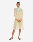 A women wearing white colored full sleeves designer dress with knee length.