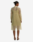 A women wearing white colored full sleeves designer dress with knee length.