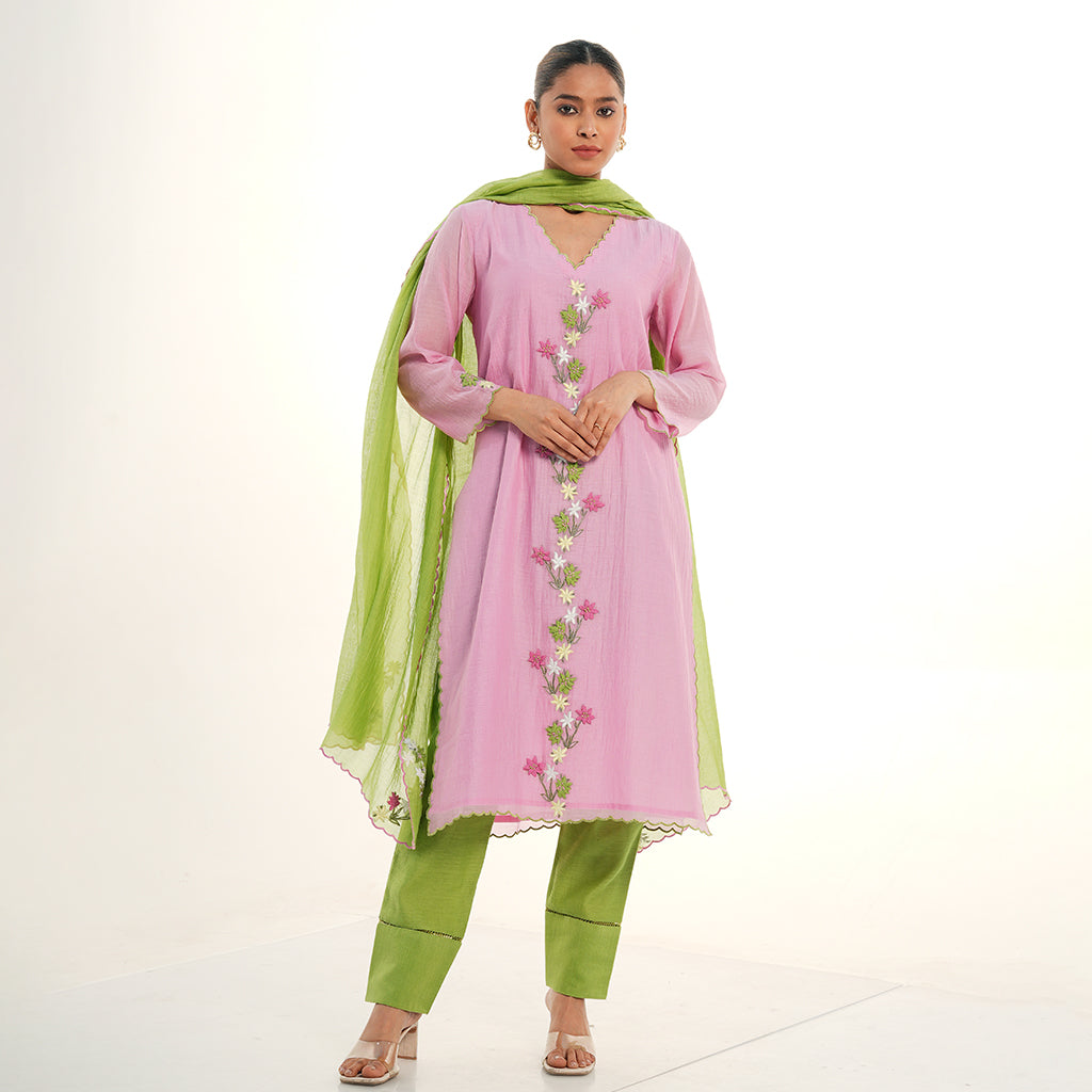 A women wearing light pink colored kurta set with green colored pants with green dupatta.