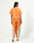 A woman wearing orange and white colored oversized co-ord set.