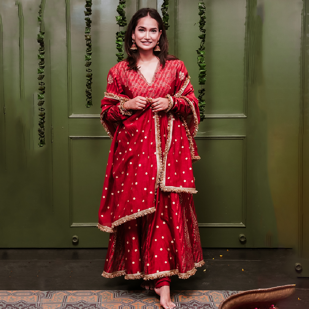 A women wearing Red Anarkali Suit with Heavy Dupatta.