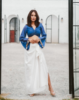 A woman wearing Blue Colored Blouse and White Drape Skirt Co-ord Set.