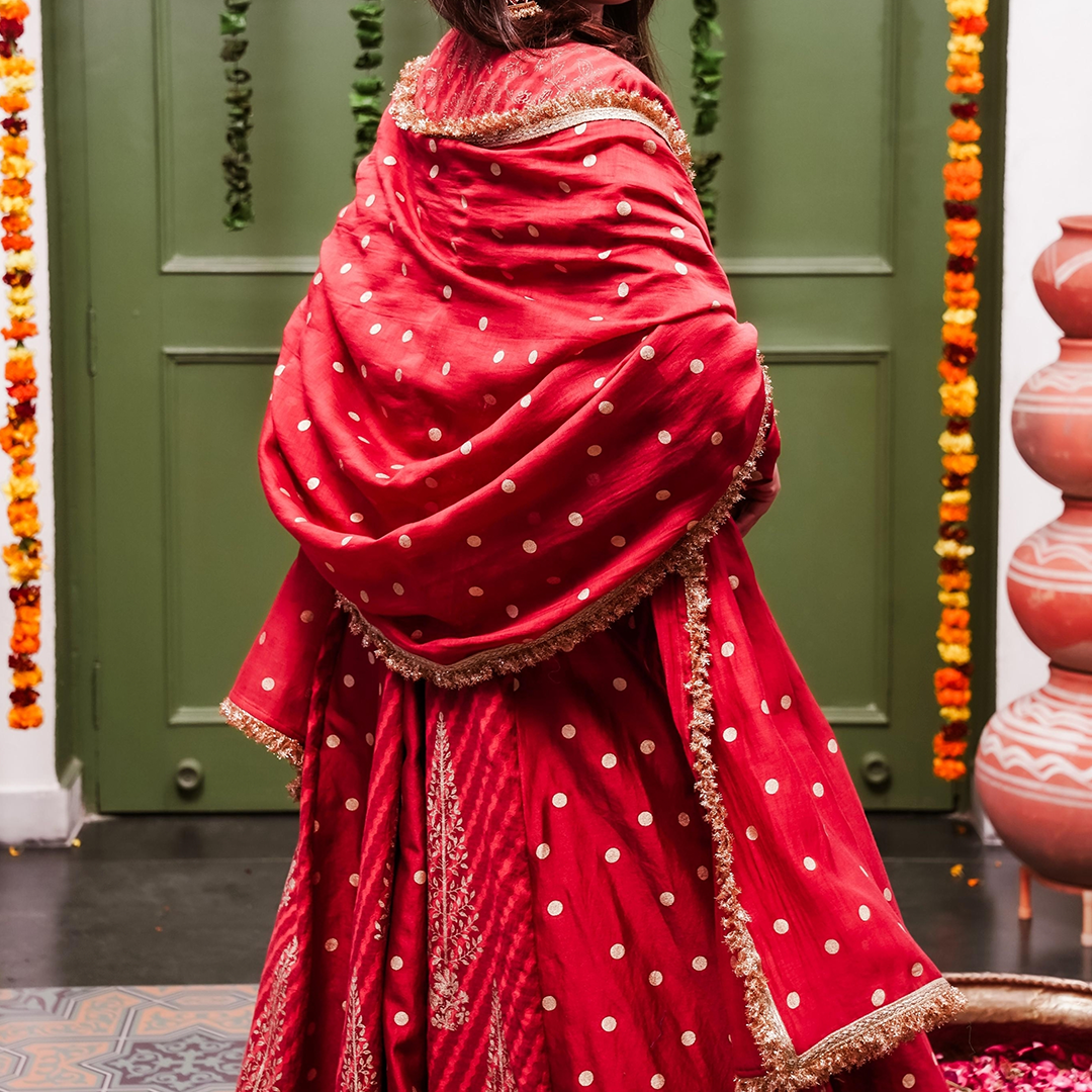 A women wearing Red Anarkali Suit with Heavy Dupatta.