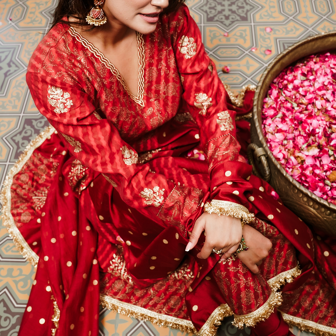 A women wearing Red Anarkali Suit with Heavy Dupatta.