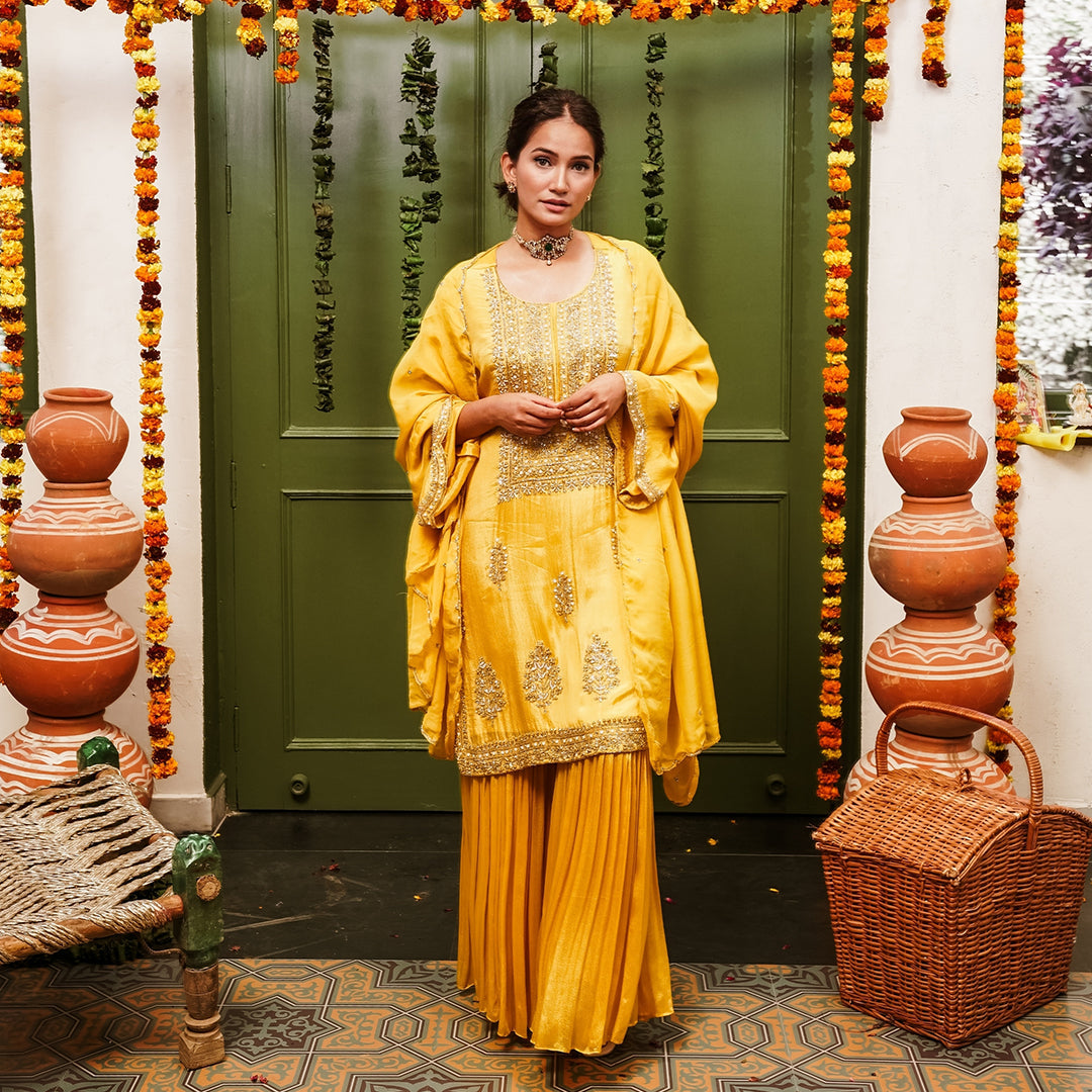 A woman wearing Yellow Sharara Suit set with Dupatta.