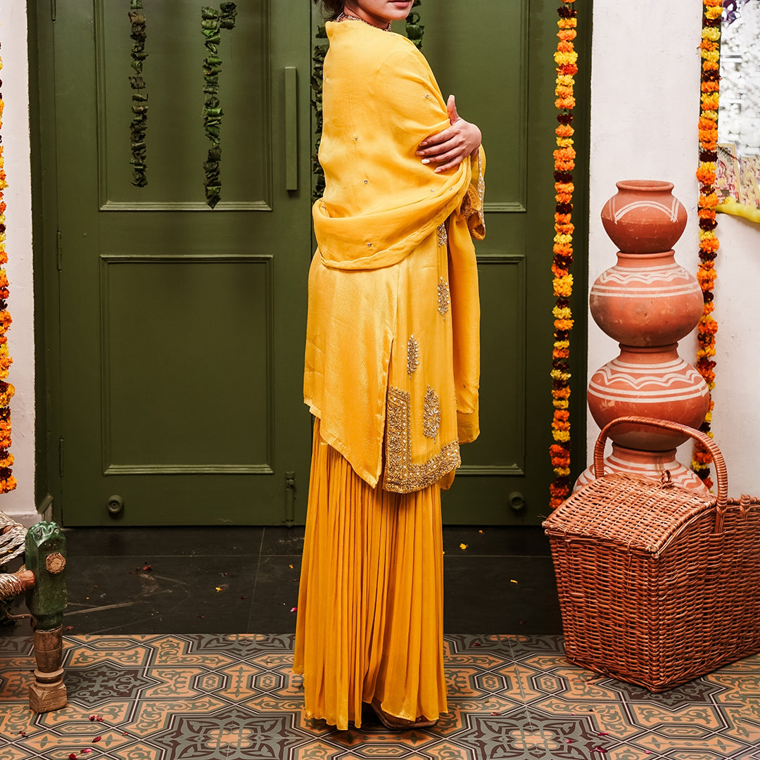 A woman wearing Yellow Sharara Suit set with Dupatta.