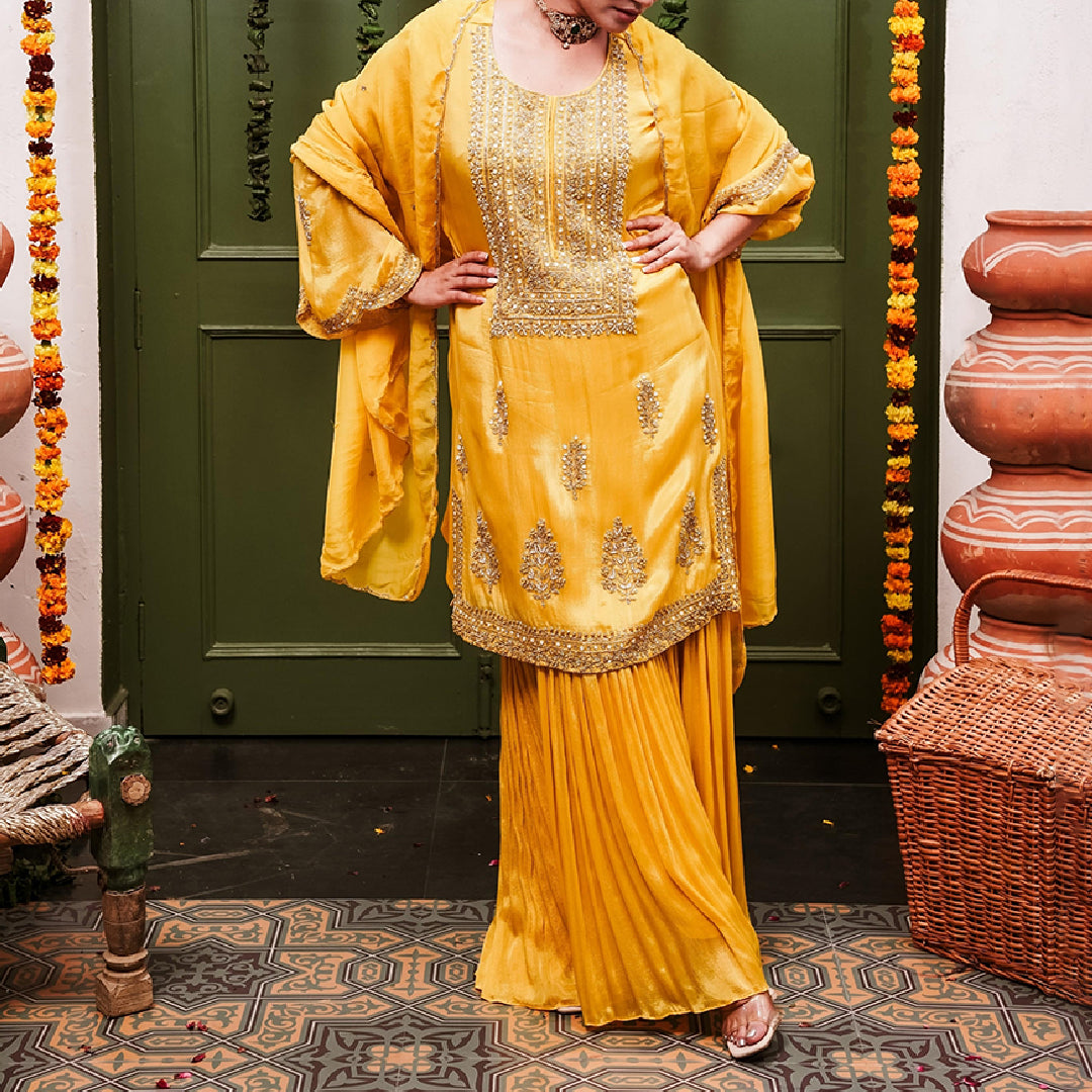 A woman wearing Yellow Sharara Suit set with Dupatta.