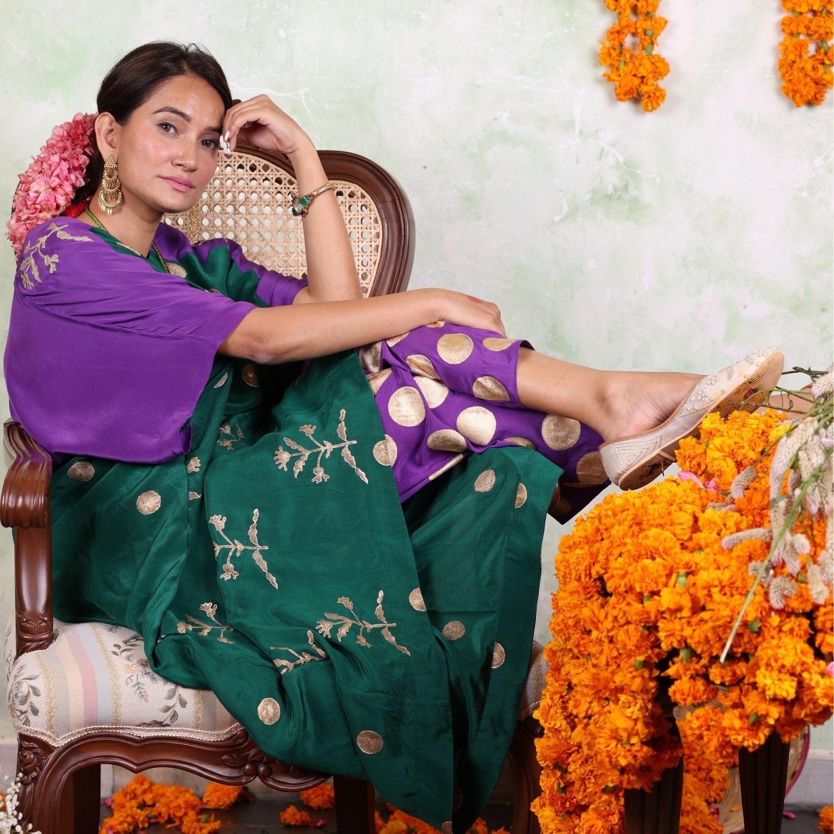 A women sitting on a chair wearing Kaftan Kurta Set of green and purple colour.