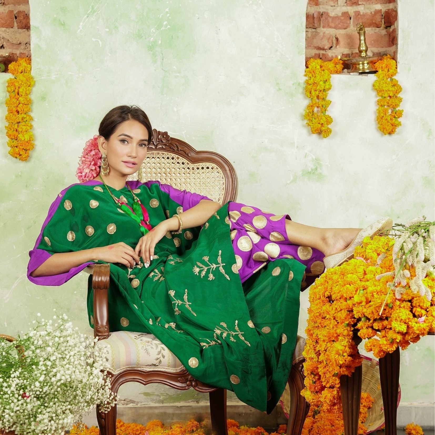 A women sitting on a chair wearing Kaftan Kurta Set of green and purple colour.