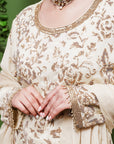 A women wearing beige colored Sharara Suit Set with Dupatta.