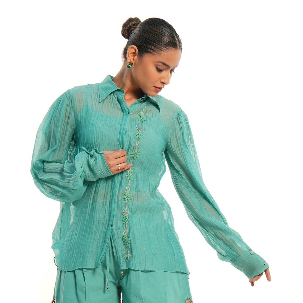 A women wearing full sleeves aqua colored shirt with shorts.