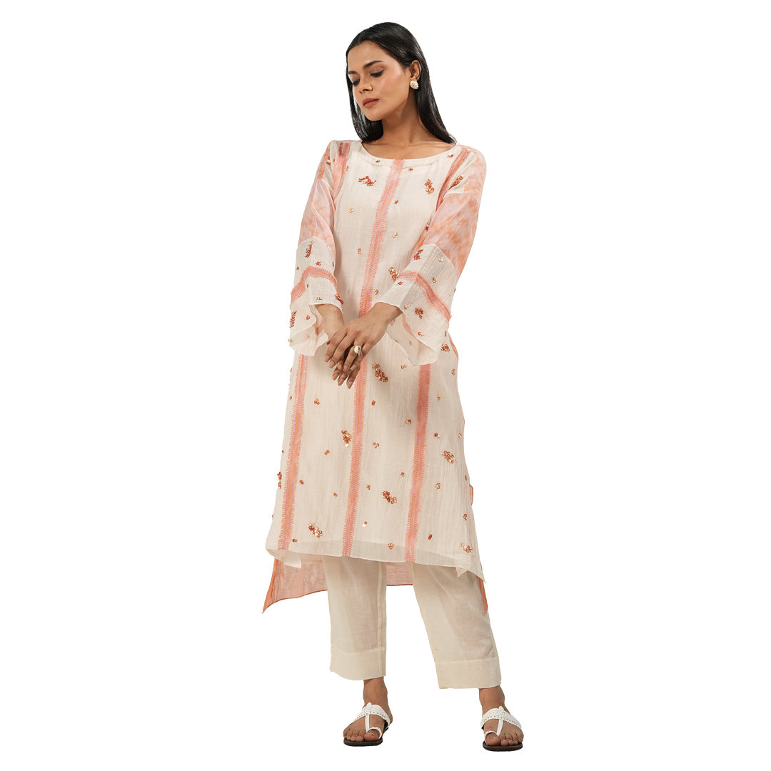 A women wearing Peach Colored Kurta Set with white pants.