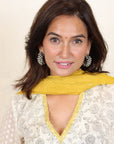 A women wearing white and yellow kurta set with Dupatta.